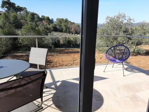 a balcony with a table and a purple chair at Studio au calme tout équipé in Pourrières