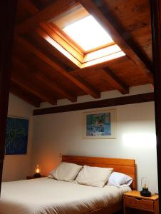 a bedroom with a bed with a skylight at Olatuenea casa rural in Sumbilla