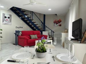 a living room with a red couch and a red chair at Casa Yaye Centro Écija in Écija