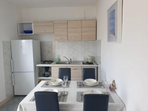 a kitchen with a table with chairs and a white refrigerator at Maiden Apartments in Trogir
