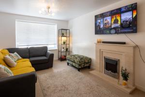 a living room with a couch and a fireplace at Cozy Glam Patchway Garden House Sleep 9 Mid-Long Term Welcome in Bristol