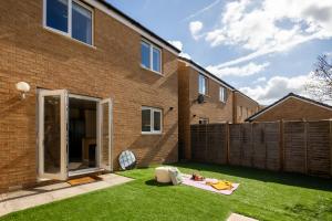 a backyard with a fence and green grass at Cozy Glam Patchway Garden House Sleep 9 Mid-Long Term Welcome in Bristol