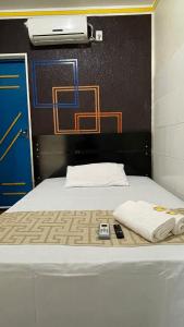 Pôrto da FôlhaにあるPousada Portofolhenseのベッド1台(タオル2枚、リモコン付)