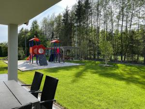 podwórze z placem zabaw ze stołem i krzesłami w obiekcie BURSZTYNOWA-PRZYSTAŃ w mieście Lubiatowo