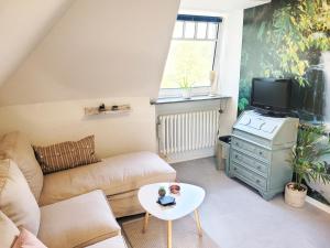 a living room with a couch and a tv at Wohnung zwischen Nord- und Ostsee mit Fitnessraum in Ostenfeld