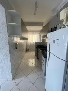 a white kitchen with a refrigerator and a sink at Recanto das Ondas in Ubatuba