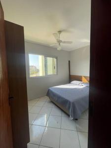 a bedroom with a bed and a ceiling fan at Recanto das Ondas in Ubatuba +9 photos