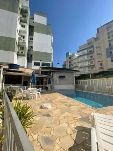 a patio with a swimming pool and some buildings at Recanto das Ondas in Ubatuba