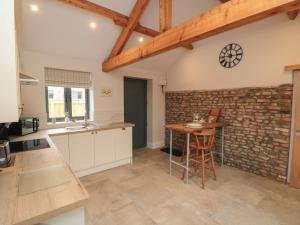 a kitchen with a brick wall and a table at The Tack Room in Thirsk +6 photos