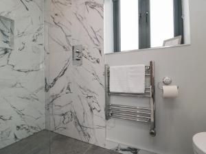 a bathroom with a marble shower with a mirror at The Tack Room in Thirsk