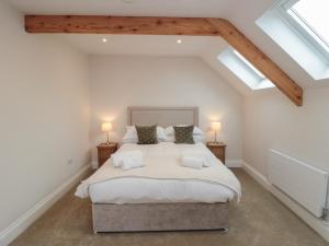 a bedroom with a large bed with skylights at The Mill House in Thirsk