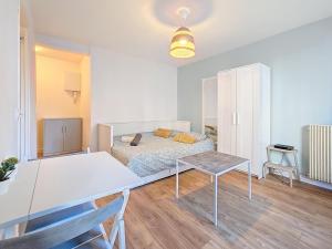 a bedroom with a bed and a desk and a table at Appartement confortable et calme à Tours centre in Tours