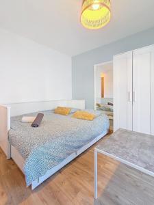 a white bedroom with a bed and a table at Appartement confortable et calme à Tours centre in Tours +1 photo