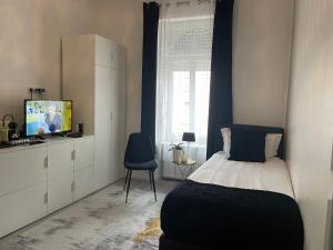 EXECUTIVE SINGLE ROOM WITH EN-SUITE in GUEST HOUSE CITY CENTRE電視和／或娛樂中心