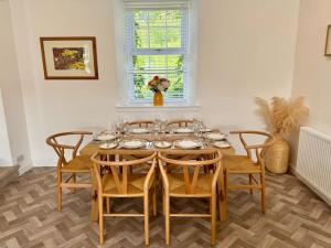 a dining room with a wooden table and chairs at Country Cottage on Private Estate in Minishant