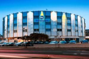 a building with cars parked in a parking lot at Best Western London Heathrow Ariel Hotel in Hillingdon