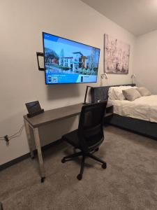 a bedroom with a desk and a bed and a television at My TRI Suites Reno Sparks in Clark