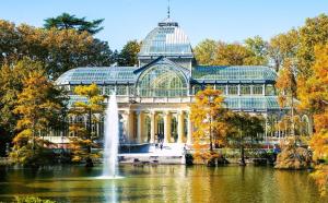 a conservatory in a park with a fountain and a pond at Habitaciones individuales en apartamento in Madrid