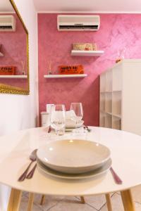a dining room with a white table with wine glasses at Suite Angeli, a due passi da Assisi in Santa Maria degli Angeli