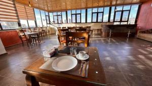 a restaurant with a table and chairs and a piano at Tell Madaba in Madaba