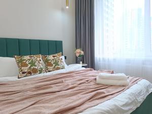 a bedroom with a large bed with a green headboard at Riviera apartment for 6 persons in Almaty