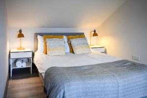 a bedroom with a large bed with two night stands at Diamond House - 4 bedroom luxury home in Airdrie