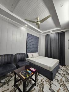 a bedroom with a bed and a couch and a table at Hotel Tulip Inn, Gulberg in Lahore