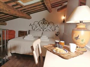 a bedroom with a bed and a table with a tray of food at Tuscan rooms in Greve in Chianti