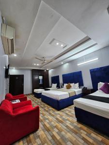 a hotel room with two beds and a red couch at Hotel Tulip Inn, Gulberg in Lahore
