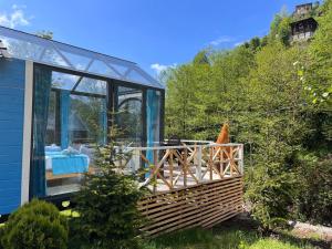 a glass house with a bench in a garden at Moon River Bungalow in Ayder Yaylasi