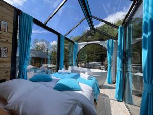 a bedroom with a bed and a tub in a glass house at Moon River Bungalow in Ayder Yaylasi +102 photos