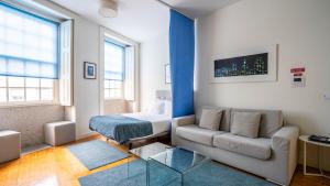 un salon avec un canapé et un lit dans l'établissement Home At Porto - Aliados Apartments, à Porto