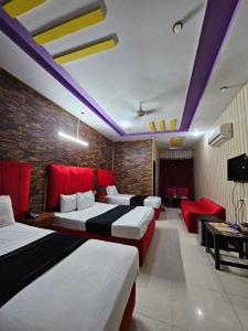 a hotel room with three beds and a couch at Hotel Tulip Inn, Gulberg in Lahore