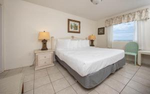 a bedroom with a bed and a desk and a window at Driftwood Towers 5A condo in Gulf Shores +22 photos