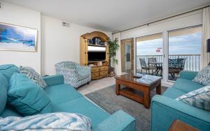 a living room with two blue couches and a television at Driftwood Towers 5A condo in Gulf Shores