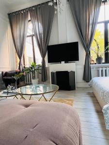 a living room with a table and a tv at Cozy apartment in Rīga