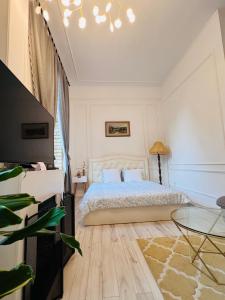 a white bedroom with a bed and a table at Cozy apartment in Rīga +15 photos