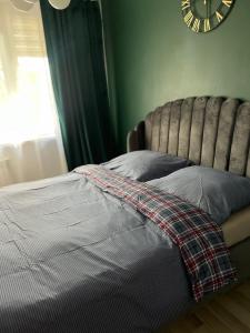 a bedroom with a bed with a clock on the wall at Marszałkowska loft in Kielce