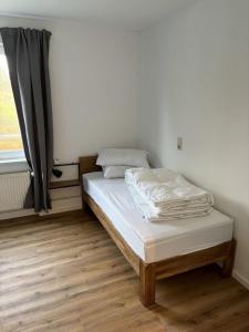 a bed sitting in a room with a window at Rathauswiese Ferienwohnung in Braunlage +2 photos