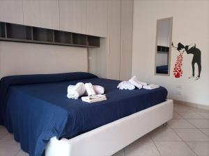 a bedroom with a blue bed with towels on it at Appartamento La collina verde in Penne