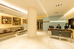 a man sitting at a desk in a lobby at The Shalimar Hotel, Kemps Corner in Mumbai