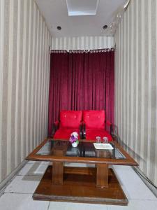 a living room with a red couch and a table at Hotel Tulip Inn, Gulberg in Lahore