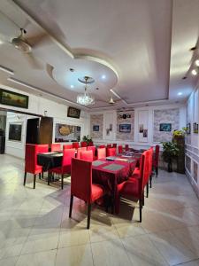 a dining room with a table and red chairs at Hotel Tulip Inn, Gulberg in Lahore