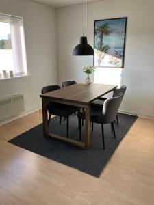 a dining room with a wooden table and chairs at Lejlighed i naturskønt område in Bratten Strand +10 photos