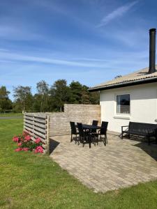 a patio with chairs and a table in a yard at Lejlighed i naturskønt område in Bratten Strand