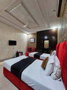 a hotel room with two beds and a television at Hotel Tulip Inn, Gulberg in Lahore
