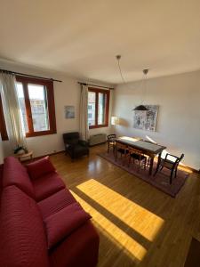 a living room with a red couch and a table at Casa Mazzini in Monselice