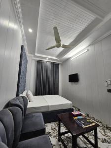 a room with a bed and a couch and a table at Hotel Tulip Inn, Gulberg in Lahore