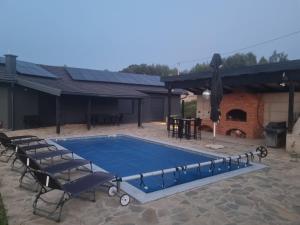 a swimming pool in a patio with a table and chairs at Villa OlieMM in Česma