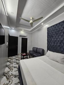 a bedroom with a bed and a couch and a table at Hotel Tulip Inn, Gulberg in Lahore